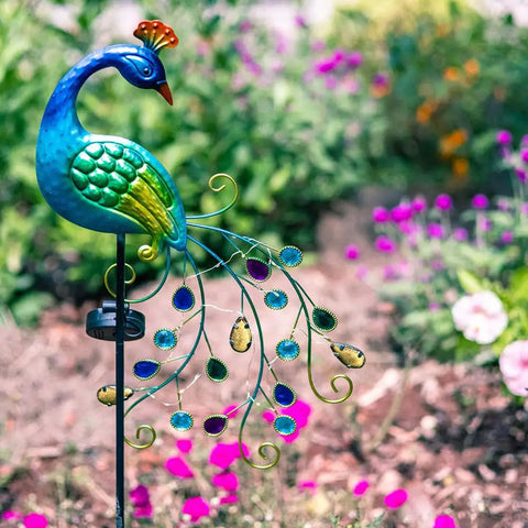 Metal Peacock Solar Garden Lights Stakes, Waterproof Path Lights for Outdoor Patio Lawn Yard Decor, Warm LED Glow, Cool Backyard Vibe with Peacock Flair, colorful flowers in garden background.