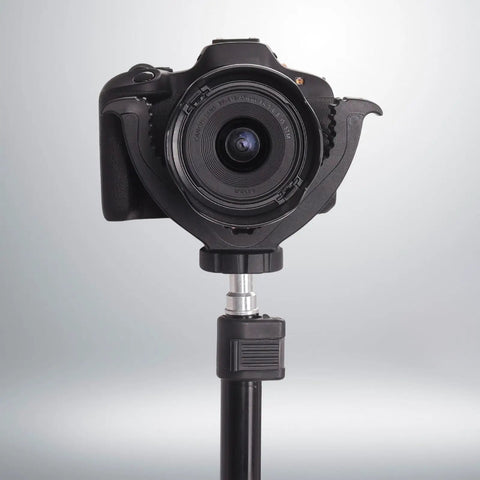 Camera mounted on shaped rifle rest with portable tripod mount for outdoor shooting and target practice, black yoke head