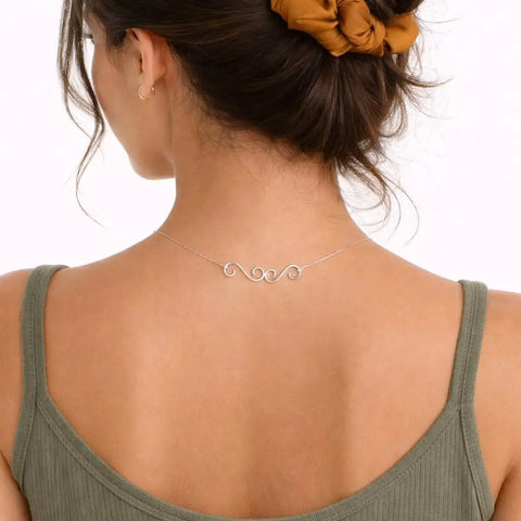 Woman wearing a necklace with Set Of 4 S Hook Necklace Extenders With Gold And Silver Swirl Hooks Durable Metal Jewelry Extenders For Necklaces And DIY Crafting Tarnish Resistant S Shaped Connectors shown from back