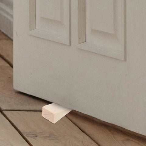 Beige Triangular Wood Door Stopper Wedges Nail Free And Easy To Use Bumper Set shown under a door on wooden floor