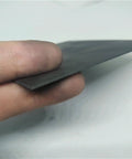Person holding a high temp graphite plate for electrodes and pyrolysis blocks, highlighting its compact structure and low porosity material.