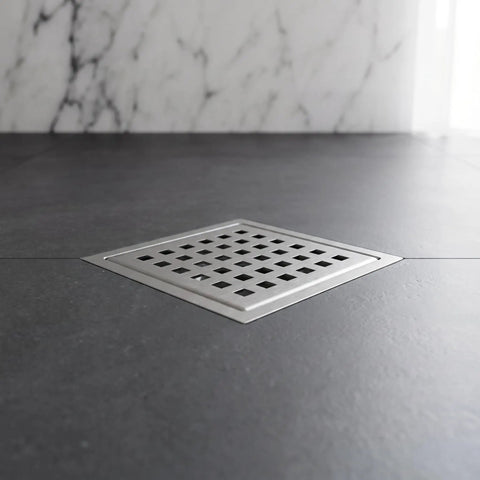 Modern Square Shower Drain With Brushed Nickel Finish installed flush in a dark shower floor with grid cover.
