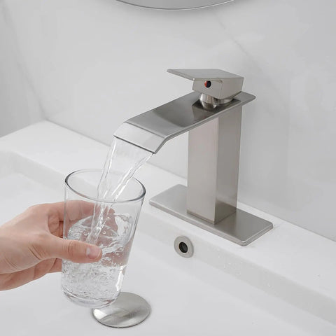 Swanky Brushed Nickel Waterfall Bathroom Faucet With Single Handle For Modern Sinks And 1 Or 3 Hole Installations, pouring water into glass
