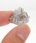 10 Pack Linear Switch Stems For Mechanical Keyboard Mods featuring a gray POM switch stem held between fingers.