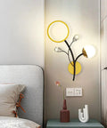 Top Shelf Modern Wall Sconce Packed With Crystal Trim And Slick Three Color Dimmable Lighting For Master Bedrooms Living Rooms And Hallways Wire Drawn Metal Body, mounted above a grey bed.