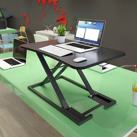 Portable Sit Stand Desk Converter With Heavy Duty Dual Tray Ergonomic Stand on a green desk holding laptop and keyboard.