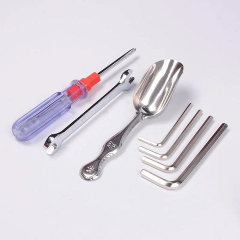 Set of tools including a screwdriver, spanner, scoop, and hex keys on white background.