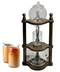 Smooth Cold Brew Coffee Maker Tower With Precision Drip Control Heat Resistant Borosilicate Glass And Solid Wooden Base 600ml next to iced coffee drinks.