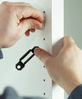 Person installing a 100 Piece Concealed Furniture Fasteners For Floating Shelves And Bookcases Featuring Cold Rolled Steel And Tough Plastic Clips.