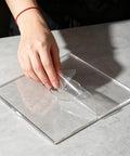 Hand removing protective film from 2 Piece Heavy Duty Acrylic Baby Closet Divider Router Template With Curved Hanger Cutting Stencil.