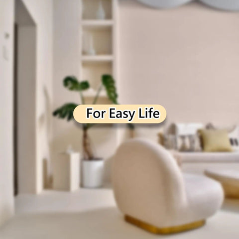 Modern living room with beige curved chair, white walls, and green plant.