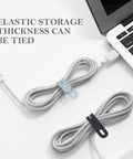 Silicone Cable Ties Set, 30 Pcs Reusable Washable Cable Management Straps With Adjustable Lock Buckles, High Elasticity For Home Office School Travel, Tangle Free Cord Organizer In Six Colors securing cables next to a laptop.