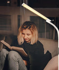 Person reading under tall floor lamp with 5 color modes and 5 brightness levels, remote and touch control, 360 degree gooseneck reading light.