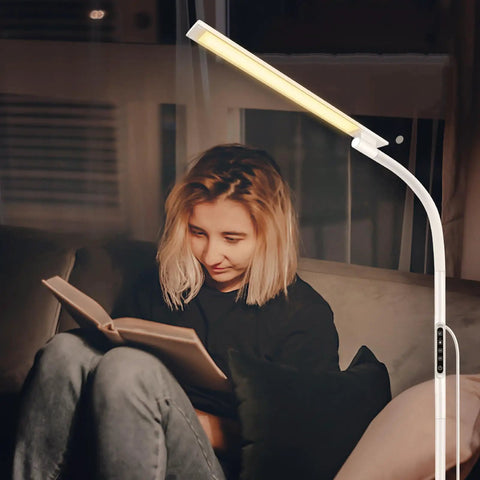 Person reading under tall floor lamp with 5 color modes and 5 brightness levels, remote and touch control, 360 degree gooseneck reading light.
