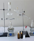 Front view of two stainless steel lab jack stands with clamps and glassware on a lab bench