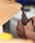 Close-up of hand using a drill with the Twenty Piece Pro Grade Abrasive Flap Wheel Sander Set for wood finishing.