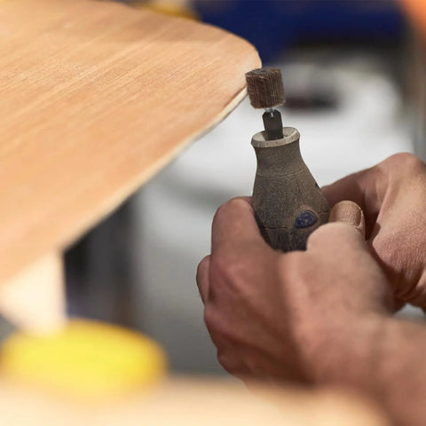 Close-up of hand using a drill with the Twenty Piece Pro Grade Abrasive Flap Wheel Sander Set for wood finishing.