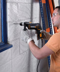 User operating a Heavy Duty 600 Watt Impact Drill Driver With 13 Mm Keyless Chuck and Variable Speed Control on a concrete wall.