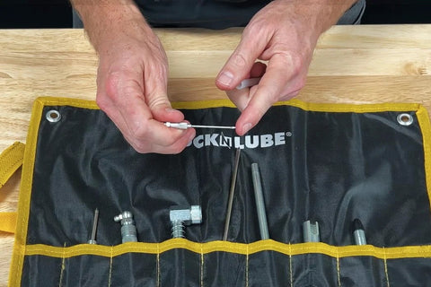 LockNLube grease injector needle kit in a black pouch with yellow trim; metal tips visible.