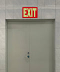 Glow In The Dark Emergency Exit Signs 2 Pack Photoluminescent Vinyl For 50 Feet Visibility No Wiring Needed Flexible Arrows System For Easy Setup Lets You Show Clear Safe Path In Any Hallway Or Stairwell. above gray door