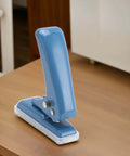 Blue Compact Five Point Five Millimeter Hole Puncher Built Tough Metal Handheld Punch on wooden desk.