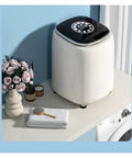 Slick Pocket Sized Portable Washer Dryer Combo Featuring A Heated Gentle Wash Cycle on countertop with flowers and towels.