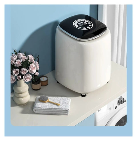 Slick Pocket Sized Portable Washer Dryer Combo Featuring A Heated Gentle Wash Cycle on countertop with flowers and towels.