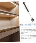 Metal gas-spring hinge with mounting disk for soft-close cabinet doors, shown beside wood cabinet interior