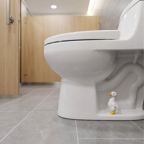 Total Bath Refresh With These Straight Up Cute Ceramic Duck Toilet Bolt Caps Set Of Two Standing Screw Covers Featuring Easy Peasy Setup And Real Deal Rust Protection, ceramic duck toilet bolt cap next to white toilet.