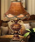 Tiffany Style Table Lamp With Floral Jeweled Design In Resin And Bronze Finish Cloth Lampshade Warm White LED Not Dimmable 360 Degree Illumination Victorian Desk Or Bedside Light For Living Room Decor displayed on a classic wooden table in a cozy living room setting.