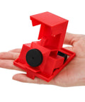 Red clamp-on circuit breaker lockout device for 480-600V single and multi-pole breakers, shown in hand, large size, OSHA compliant.