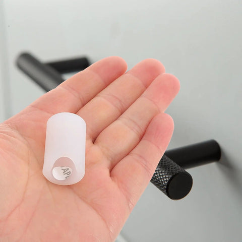 Hand holding a white Silicone Round Corner Protector for Wardrobe and Drawer Handles with soft touch texture