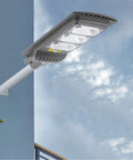 Heavy Hitting 120W Solar Floodlight With Twin Motion Sensors And Dusk To Dawn Auto Lighting, Includes Handy Remote, No Sweat Install For Patios Driveways And Secure Yard Perimeter mounted on wall.