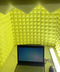 Solid Portable Desktop Soundproof Booth Cube Packed With Dense Acoustic Foam Panels, yellow interior with a laptop for recording.