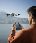 Man using Air 3S Fly More Combo With Dual Screen Remote Controller 1 Inch CMOS Wide Angle And Medium Tele Cameras 4K 60FPS HDR