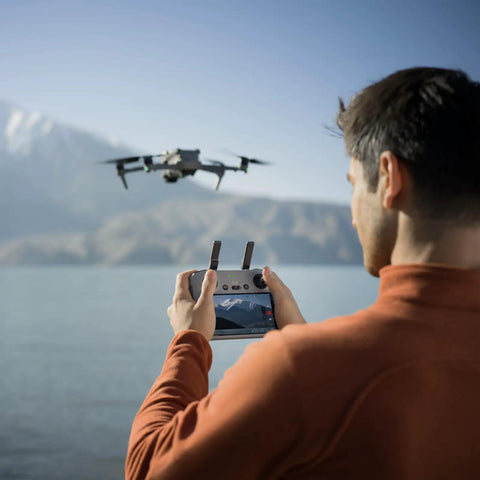 Man using Air 3S Fly More Combo With Dual Screen Remote Controller 1 Inch CMOS Wide Angle And Medium Tele Cameras 4K 60FPS HDR