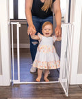 Ninja Level Heavy Duty Auto Close Baby Gate Featuring Hella Low Half Inch Threshold shown with child and parent in doorway.