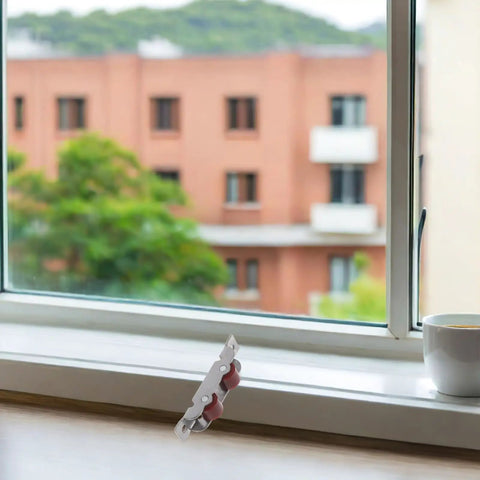 Four Pack Heavy Duty Stainless Steel Double Wheel Sliding Door Roller Assembly With A Slick Polished Finish And Rock Solid Wear Resistant Pulleys For Zero Hassle Window Track Operation on a window sill.