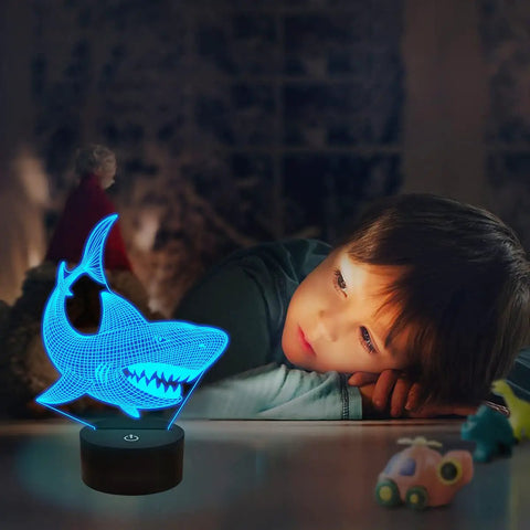 Child admiring Shark 3D Illusion Night Light With Touch Control And Remote 16 Color USB LED Desk Lamp in dim room