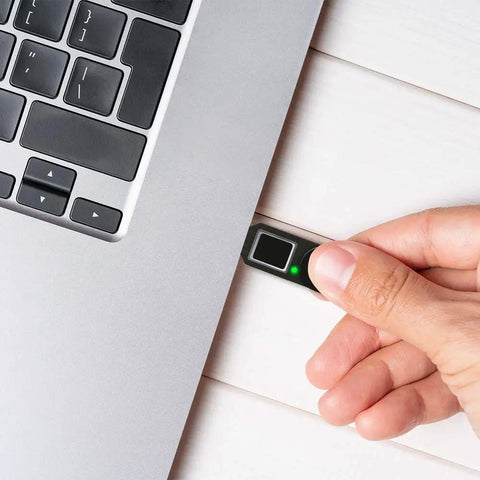 Hand inserting FIDO2 Fingerprint USB A Security Key for Passwordless Login into laptop for two factor authentication