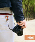 Person using Dope Lightweight 12KN Aluminum Carabiner Clip Wiregate Heavy Duty for keys on pants with camera in hand