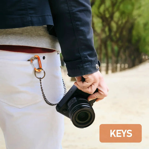 Person using Dope Lightweight 12KN Aluminum Carabiner Clip Wiregate Heavy Duty for keys on pants with camera in hand