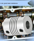 Front view of a silver Aopin 10mm-to-10mm flexible beam coupling with through bore and two set screws