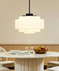 puncoll Vintage Black Milk Glass Pendant Light, 15.7'' White Chandelier hanging above a round dining table with fruit.