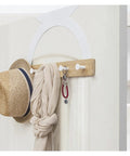 Slaying Spaces With Door Back Coat Hook Rack White Semicircle Wall Mount Hanger with hats and scarves on a door.