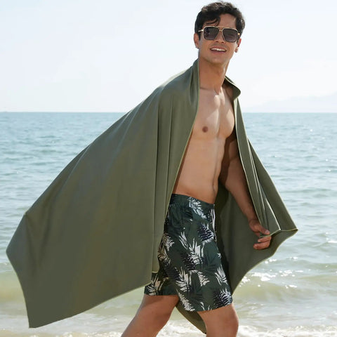 Man at beach wrapped in Ultra Compact Microfiber Towel For Travel, Gym, And Camping, Fast Dry, Super Absorbent, Lightweight, Beach Ready