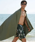 Man at beach with Ultra Compact Microfiber Travel Towel For Gym Beach And Camping With Quick Dry Super Absorbent Lightweight And Portable