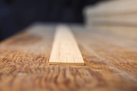 Close-up of flattened bamboo for bow making and woodworking build bows and bendable projects, showing texture and grain details.