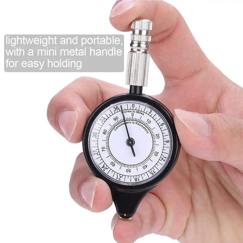 Rugged Mini Map Measuring Wheel For Dead Accurate Outdoor Distance Tracking And Trail Navigation Featuring Heavy Duty Alloy Build As Your Go To Campout Rig For Hiking Adventures Weekend Trips, held in hand with a mini metal handle.