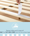 Hand peeling off the top vinyl strip from solid pine wood slats of the Queen Platform Bed Frame Low Profile Solid Pine Wood Rock Solid Heavy Duty 1000 Pound Capacity.